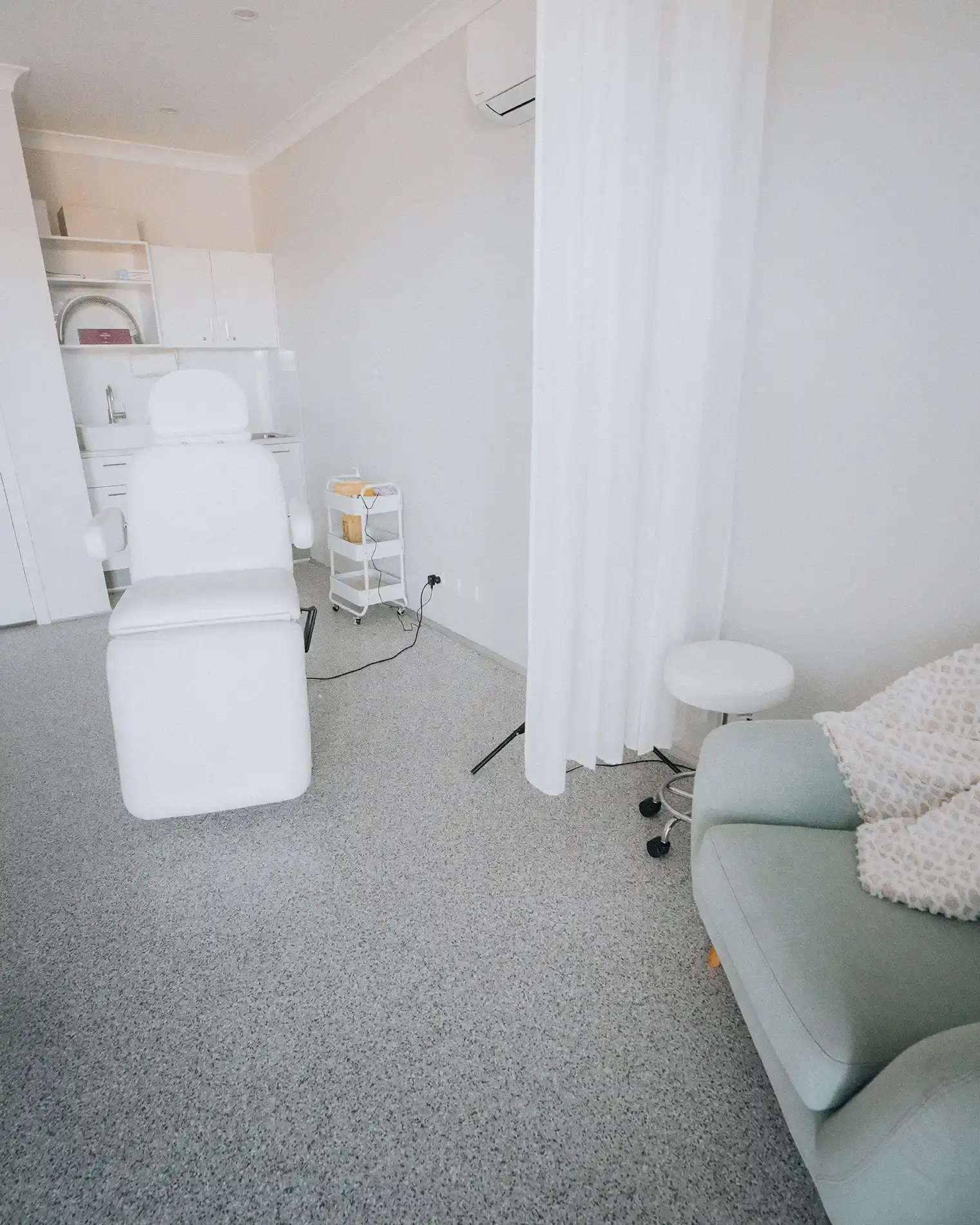 The single treatment room at Enrich Aesthetics in Wangi Wangi, with the treatment chair at one end and a curtained consultation corner at the other