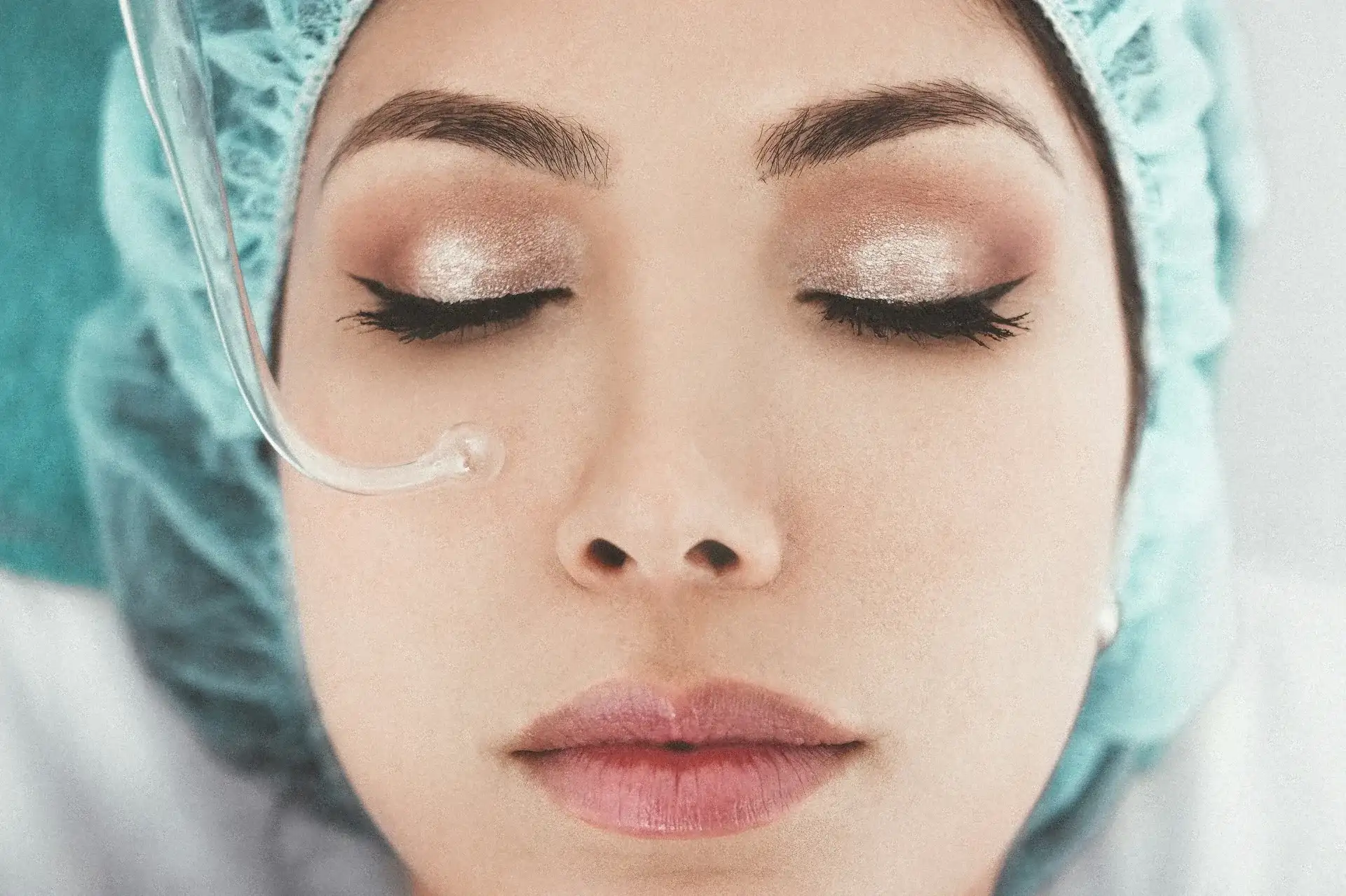 A woman resting on a treatment couch during a non-invasive facial treatment